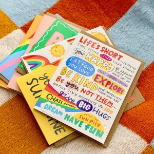 Colourful photo showing a pile of illustrated greeting cards