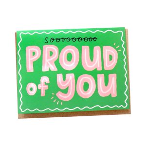 Photo of green greeting card with pink illustrated typography, "Proud of You"